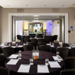 Tables and chairs set for a meeting or conference in The Ambassador Room at mercure gloucester bowden hall hotel