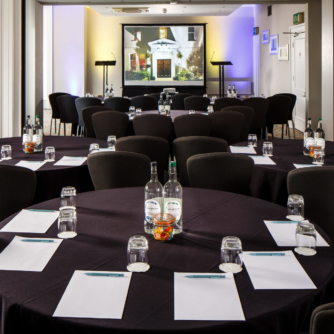 Tables and chairs set for a meeting or conference in The Ambassador Room at mercure gloucester bowden hall hotel