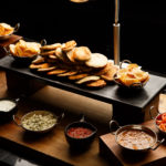 A food counter full of delicious looking dips and salsas with nan breads and poppadums as part of mercure hotels meeting food offering