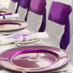 Purple place settings at the head table of a wedding