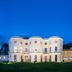 Wide view at night of the front of the hotel under floodlights