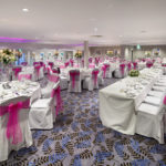 Angled view of the lakeside suite set for a wedding with pink lighting at mercure gloucester bowden hall hotel