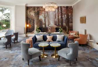 Straight on view of the lounge area with sofas chairs and artwork at mercure gloucester bowden hall hotel