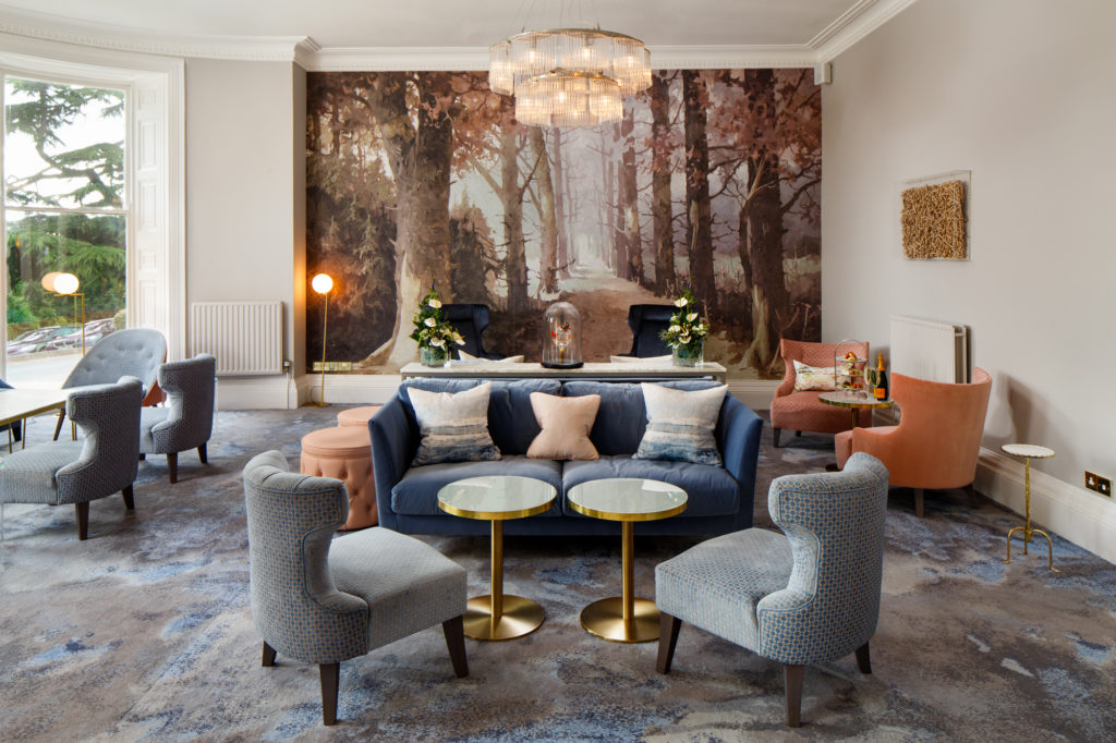 Straight on view of the lounge area with sofas chairs and artwork at mercure gloucester bowden hall hotel