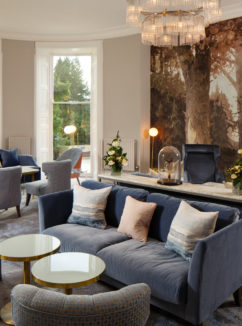 Angled view of the lounge area with sofas chairs and artwork at mercure gloucester bowden hall hotel