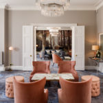 Long shot of the lounge at mercure gloucester bowden hall hotel with comfortable sofas and chairs and a large glass chandelier in the foreground