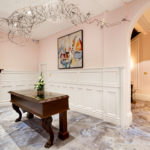 Angled view of the painting and wire wall sculpture in the reception area at mercure gloucester bowden hall hotel