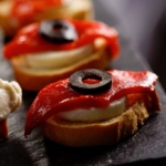 Canapes with red peppers and olives on a slate