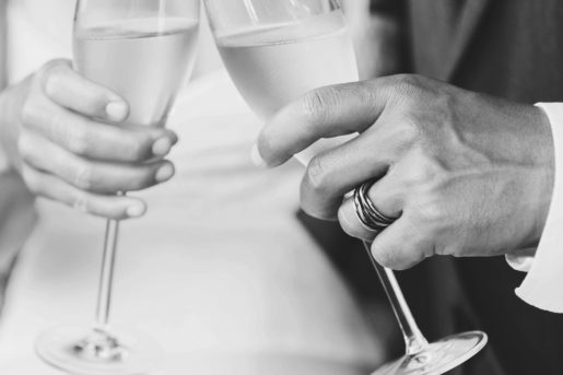 Bride and Groom toasting a glass of champagne, the picture is also black and white.